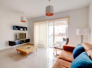 a living room with a couch and a table at Prime Location Apartment with Side Seaviews in Sliema