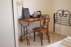 a desk with a chair and a computer on it at Hotel Restaurant Le Gardon - Pont du Gard in Collias