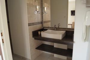 a bathroom with a sink and a mirror at Hotel Restaurant Le Gardon - Pont du Gard in Collias