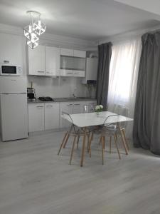una cucina con tavolo e sedie bianchi in una stanza di Apartament max. confort a Tulcea