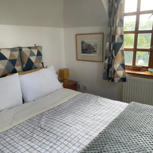 a bedroom with a bed with a checkered blanket at Carraholly in Liskeard