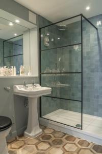 uma casa de banho com uma cabina de duche em vidro e um lavatório. em Oyster House em The Mumbles