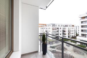 a balcony with a potted plant and a view of a city at NEW Glamorous Apartment - Gdansk Garnizon Wrzeszcz in Gdańsk