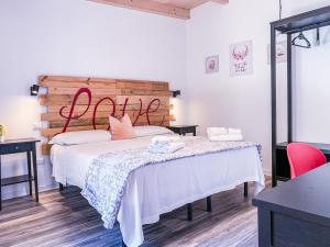 1 dormitorio con 2 camas con sábanas blancas y almohadas rosas en BB 26 Olbia, en Olbia