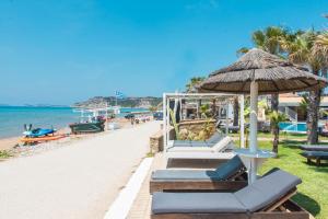 plaża z leżakami, parasolem i oceanem w obiekcie Mirage Arillas Studio Type B14 w mieście Arillas