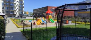 un parque con parque infantil y equipo de juegos en Amber Studio z garażem - Osiedle Bursztynowe en Kołobrzeg