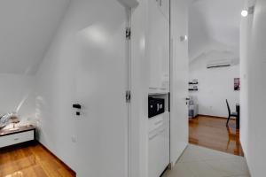 una cucina bianca con pareti bianche e pavimenti in legno di Luxury City Center Apartments a Makarska