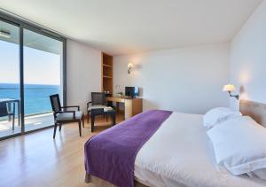 a bedroom with a bed and a view of the ocean at Golden Residence Hotel in Funchal