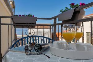 una mesa con copas y una copa de vino en el balcón en Luxury City Center Apartments, en Makarska