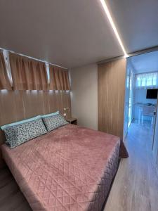 um quarto com uma cama grande e um cobertor rosa em Jolanda Vacanze em Cavallino-Treporti