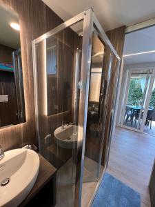 uma casa de banho com uma cabina de duche em vidro e um lavatório. em Jolanda Vacanze em Cavallino-Treporti
