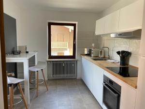 a kitchen with white cabinets and a counter top at Alpenperle Hochfeld in Tegernsee