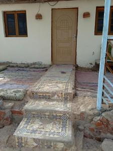 a room with a door and some mats in front of a house at sababa village in Nuweiba