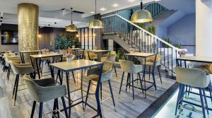 restauracja ze stołami, krzesłami i schodami w obiekcie Gran Hotel Luna de Granada w Grenadzie