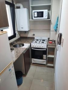 eine kleine Küche mit einem Herd und einer Mikrowelle in der Unterkunft salta centro in Salta