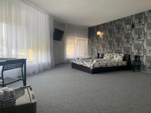 Schlafzimmer mit einem Bett, einem Tisch und einem Fenster in der Unterkunft Hotel Marijampole in Marijampolė