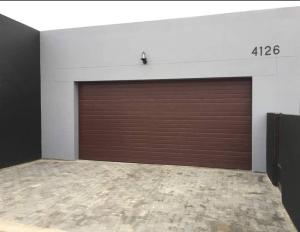 a garage with a large brown garage door at Man Cave Suite in Swakopmund