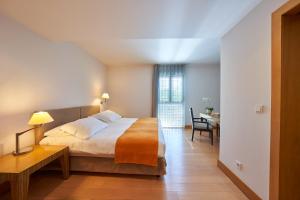 a bedroom with a bed and a desk and a table at Golden Residence Hotel in Funchal