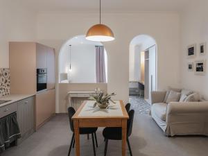 a kitchen and living room with a table and a couch at Living u HomeSuites in Lecce