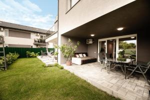 a backyard with a patio with a table and chairs at OAK Residents Siófok in Siófok