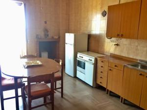 a kitchen with a table and a white refrigerator at La Casa di Zorbas in Cariati