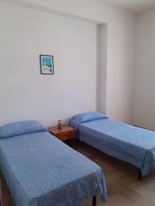 2 Betten in einem Zimmer mit blauer Bettwäsche in der Unterkunft La Casa di Zorbas in Cariati
