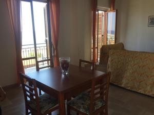 a living room with a wooden table with chairs and a window at La Casa di Zorbas in Cariati