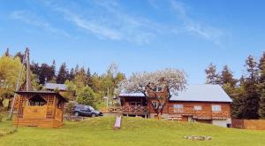 una cabaña de madera con un coche aparcado delante de él en Schronienie Orłów Domek Zawoja, en Zawoja