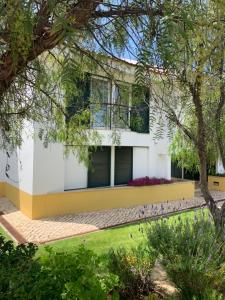 une maison à la façade jaune et blanche dans l'établissement Superb, relaxing and tranquil 3 bed Apartment in Central Algarve, à Vilamoura