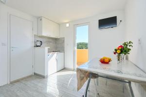 a kitchen with a table with a bowl of fruit on it at Dora&Paulo sweet countryside cottage in Babino Polje