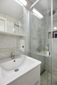 biała łazienka z umywalką i prysznicem w obiekcie Dora&Paulo sweet countryside cottage w mieście Babino Polje