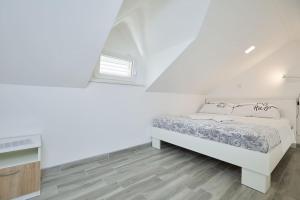 biała sypialnia z łóżkiem i oknem w obiekcie Dora&Paulo sweet countryside cottage w mieście Babino Polje