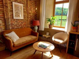 a living room with a couch and a table at Les Suites de Petit Bomal in Durbuy