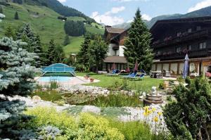 ein Hotel mit einem Garten vor einem Gebäude in der Unterkunft Haus Angela in Sankt Jakob in Defereggen