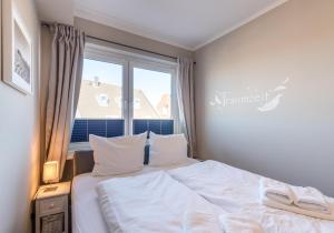 a bedroom with a white bed and a window at Appartementanlage am Strand Appartementanlage am Strand Kleine Brise - 5a in Brösum