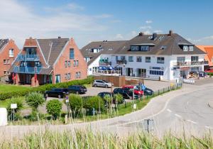 a row of houses with cars parked in a parking lot at Appartementanlage am Strand Appartementanlage am Strand Kleine Brise - 5a in Brösum