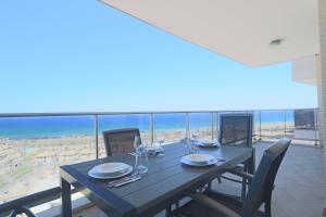 ein Esszimmer mit einem Tisch und Strandblick in der Unterkunft 057 - Blue Dreams Penthouse El Faro - comfortHOLIDAYS in Arenales del Sol