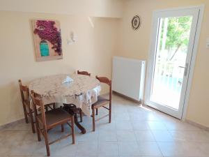 a dining room with a table and chairs and a door at Olive Grove in Kalabaka