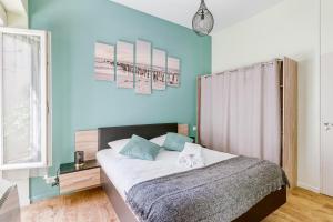 um quarto com uma cama e uma parede azul em MOANA - Petit cocon situé quartier République em Nantes