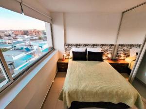 a bedroom with a bed and a large window at Altos de Tandil II centro con cochera y parrilla in Tandil +28 photos