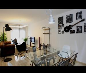 a living room with a glass table and chairs at Rock & Roll Apartament -aire acondicionado en todas las habitaciones y salón- in Deltebre
