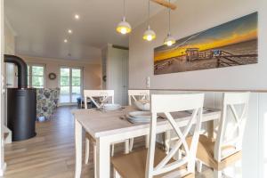 a dining room with a table and chairs at Reetdachhaus Boy's Huus Reetdachhaus Boy's Huus 5 in Sankt Peter-Ording