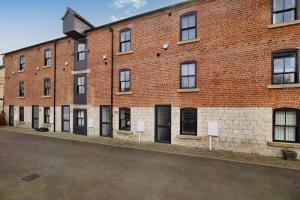 a large brick building with black doors and windows at Canalside Wharf in Retford