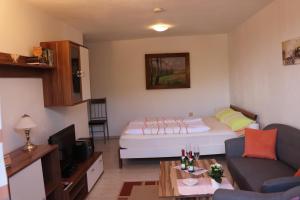 ein kleines Wohnzimmer mit einem Bett und einem Sofa in der Unterkunft FeWo Wernigerode in Wernigerode