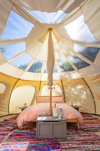 a tent with a bed and a table in it at Lloyds Meadow Glamping in Chester