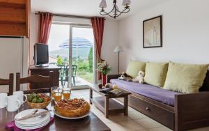 a living room with a couch and a table at Le Domaine des Cazelles by Ateya Vacances in Cajarc