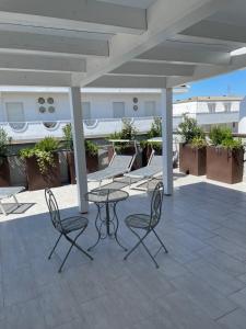 a patio with a table and chairs on a building at Casa Plauto SUITE senza cucina without kichen in Bellaria-Igea Marina