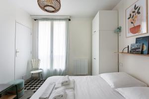 - une chambre blanche avec un lit et une chaise dans l'établissement TERRASSE FADOLI - Grande terrasse avec vue mer et cathédrale, à Marseille