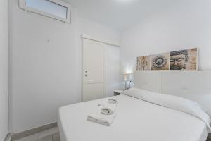 a white bedroom with a white bed and a picture on the wall at 303. MODERN, SUNNY IFONCHE WITH WiFi in Adeje