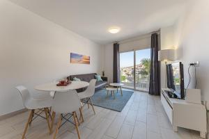 a living room with a table and chairs and a tv at 303. MODERN, SUNNY IFONCHE WITH WiFi in Adeje